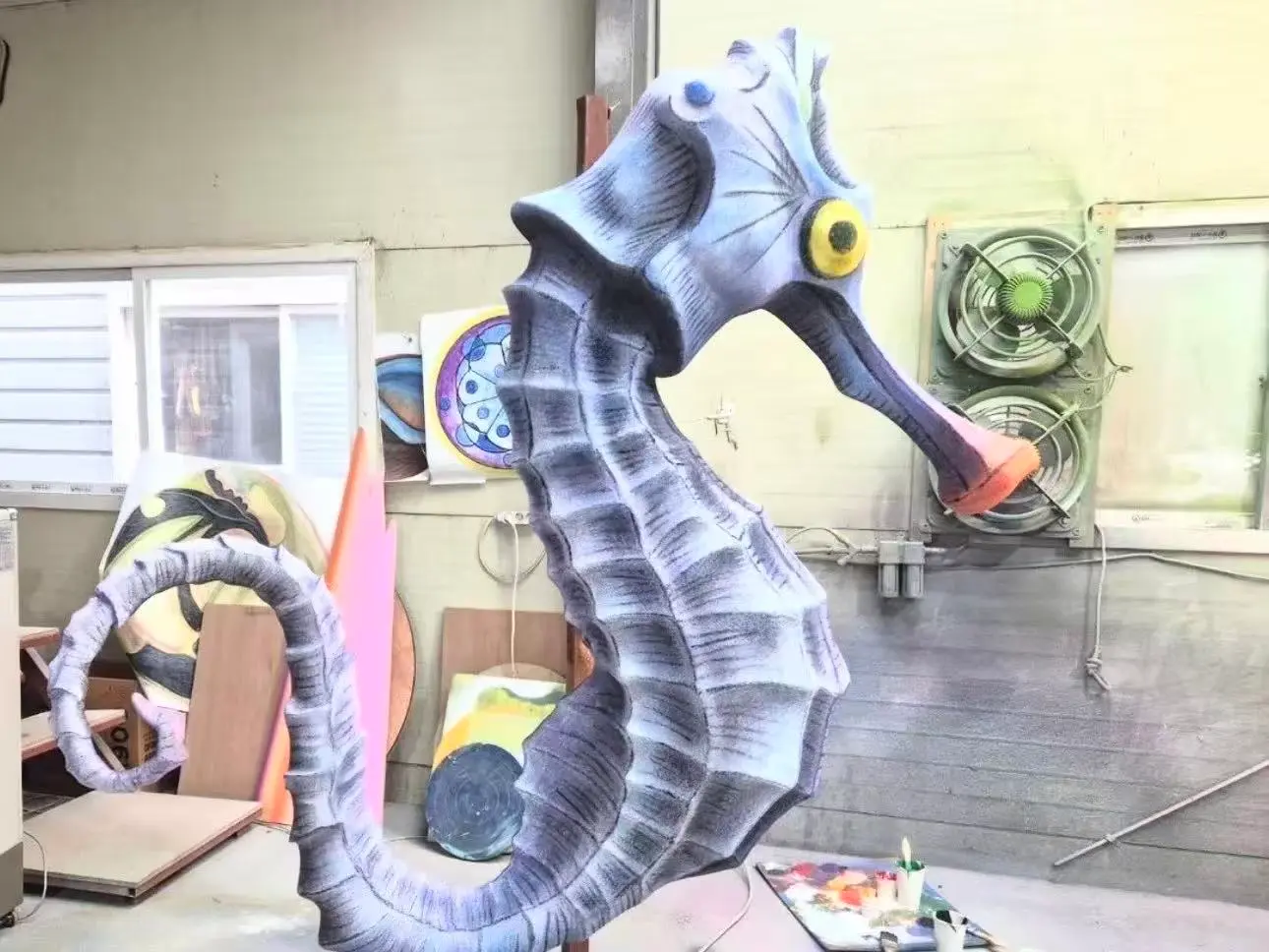 hermes painting a fiberglass seahorse sculpture